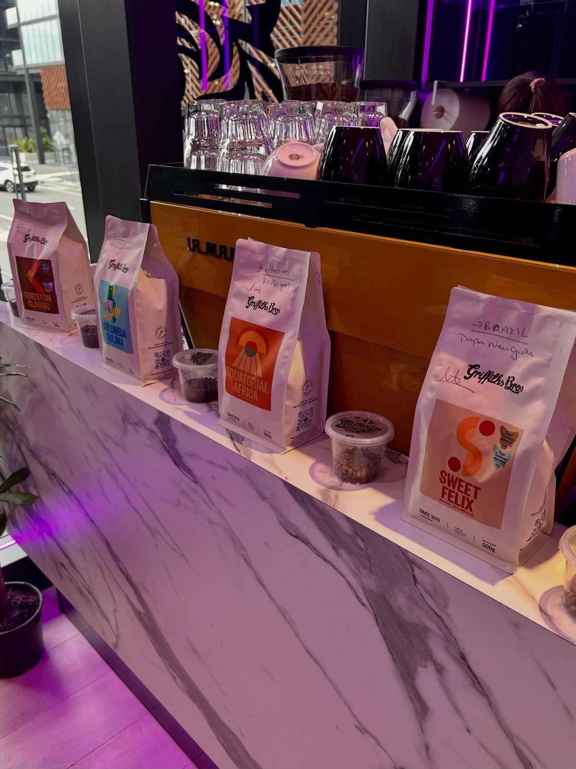 Griffiths Bros coffee bags lined up on the marble counter at Drunken Tiger, next to the espresso machine